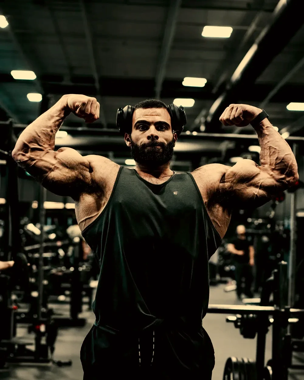 Justin holding a front double biceps pose in the gym